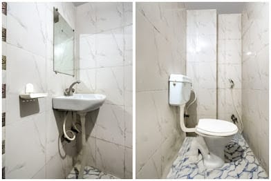 Tiled washroom with wash basin, mirror and western toilet at Happy Guest House Bodhgaya