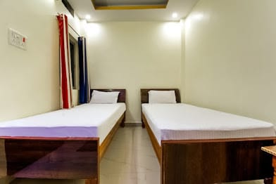 Twin bed room at Happy Guest House Bodhgaya with two separate single beds and a curtained window