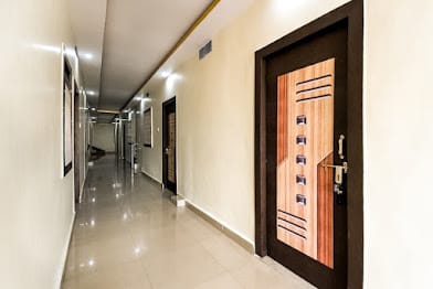 Clean guest room corridor with wooden doors at Happy Guest House Bodhgaya